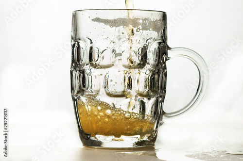 foamy beer in a transparent glass on a white background photo