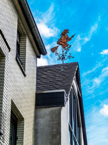 Witch weather vane on a building roof in Gemuend, District of Bitburg-Pruem in Rhineland-Palatinate, Western Germany photo