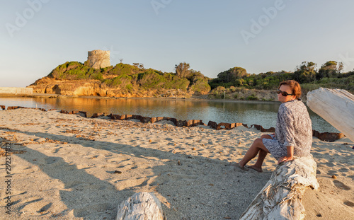 White middle age woman enjoys sunset on Corsiaca island beach. photo