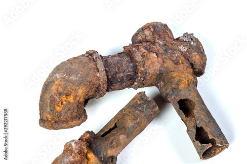 Fragments of old cast-iron water pipes on white background. After many years of operation corroded metal pipe was destroyed. Rusty steel tube with holes of metallic corrosion. Rusty cast iron, metal