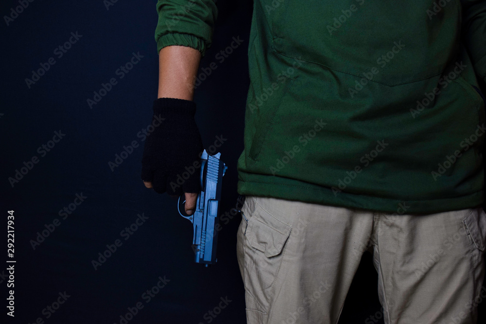 asian man holds a gun. Gun in his hand isolated on black background. asian man holds a gun. Gun in his hand isolated on black background.