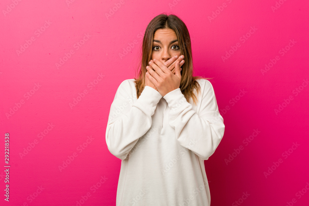 Young authentic charismatic real people woman against a wall shocked covering mouth with hands. Young authentic charismatic real people woman against a wall shocked covering mouth with hands.
