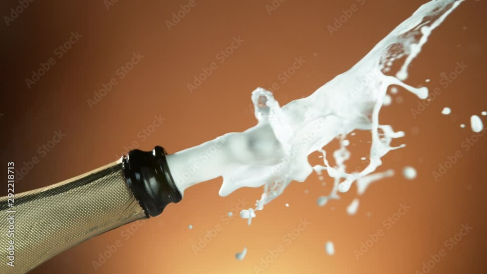 Super slow motion of Champagne explosion with flying cork closure, opening champagne bottle closeup.