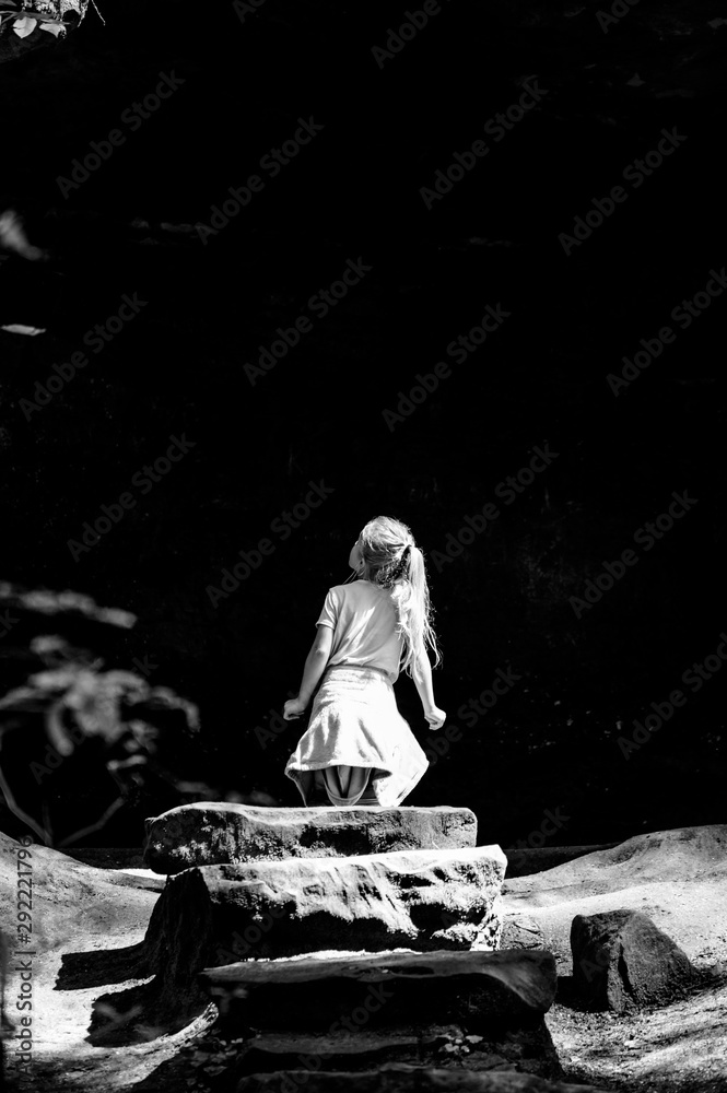 Girl standing on the rock and looking up