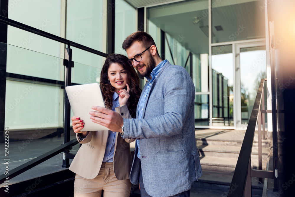 Smiling businessman and businesswoman using tablet device