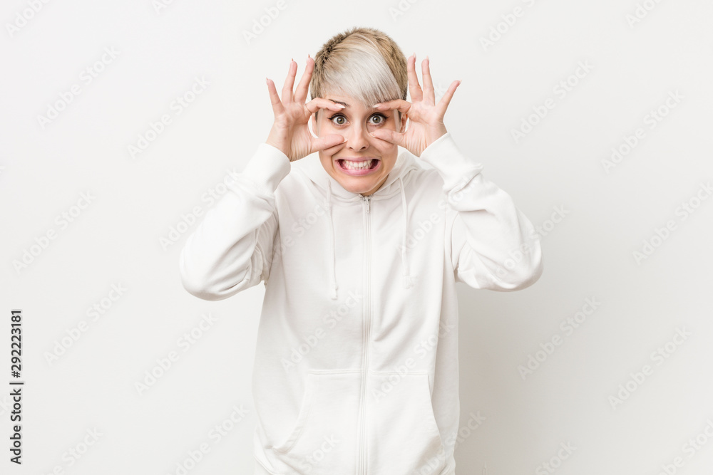 Young curvy woman wearing a white hoodie keeping eyes opened to find a success opportunity. Young curvy woman wearing a white hoodie keeping eyes opened to find a success opportunity.