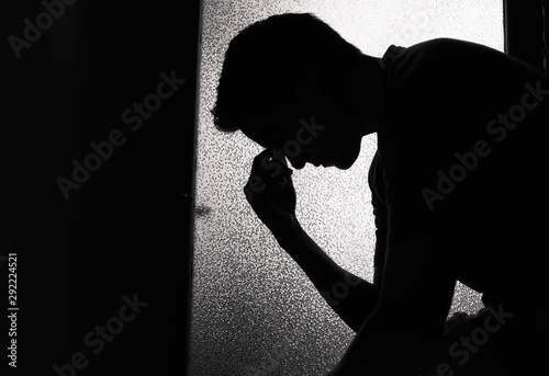 Obraz na płótnie Sad young man in a dark room