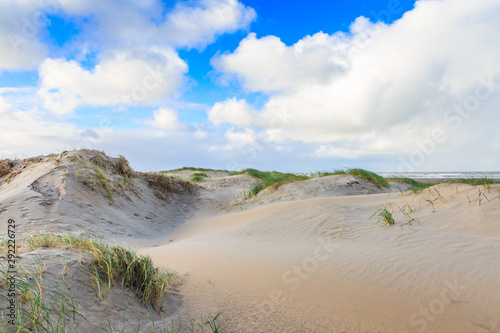 Newly formed Dunes on Dutch North Sea coast at IJmuiderslag with wind sweeping stripes in the sand against the background of blue sky with scattered clouds