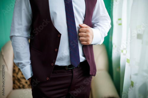 man puts on a suit on the wedding day