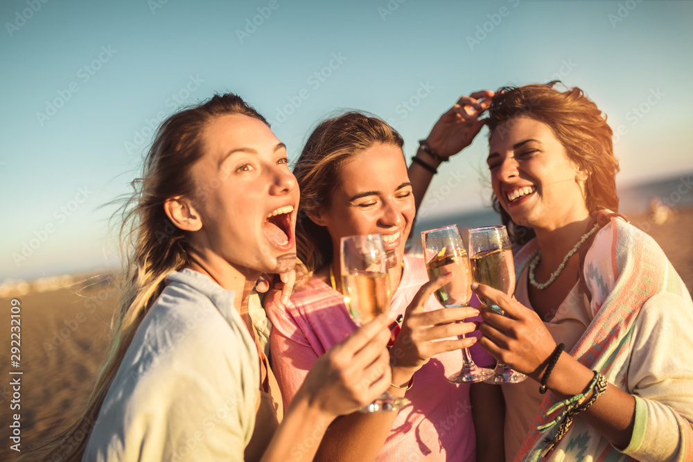 Friends having fun with champagne at celebration on beach, selective focus. Friends having fun with champagne at celebration on beach, selective focus.