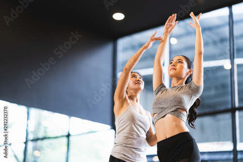 Fotografija Beautiful Asian woman learning yoga pose with female instructor in yoga studio or health club