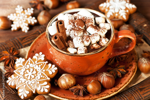Cup of hot chocolate with marshmallows and cookies on wooden background