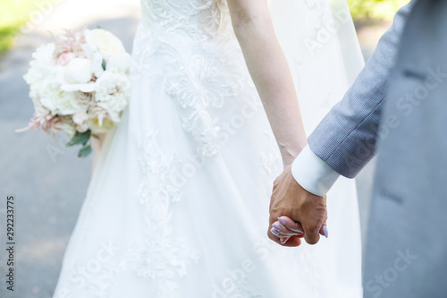 Beautiful wedding bouquet of flowers in the hands of the newlyweds