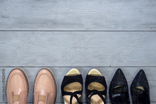 Various footwear on a wooden floor background with copy space.