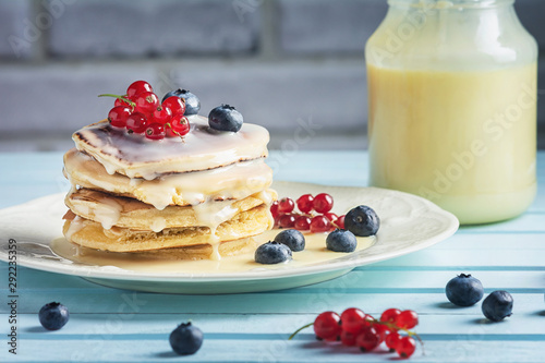 Pancakes with condensed milk are decorated with berries. Tasty breakfast.
