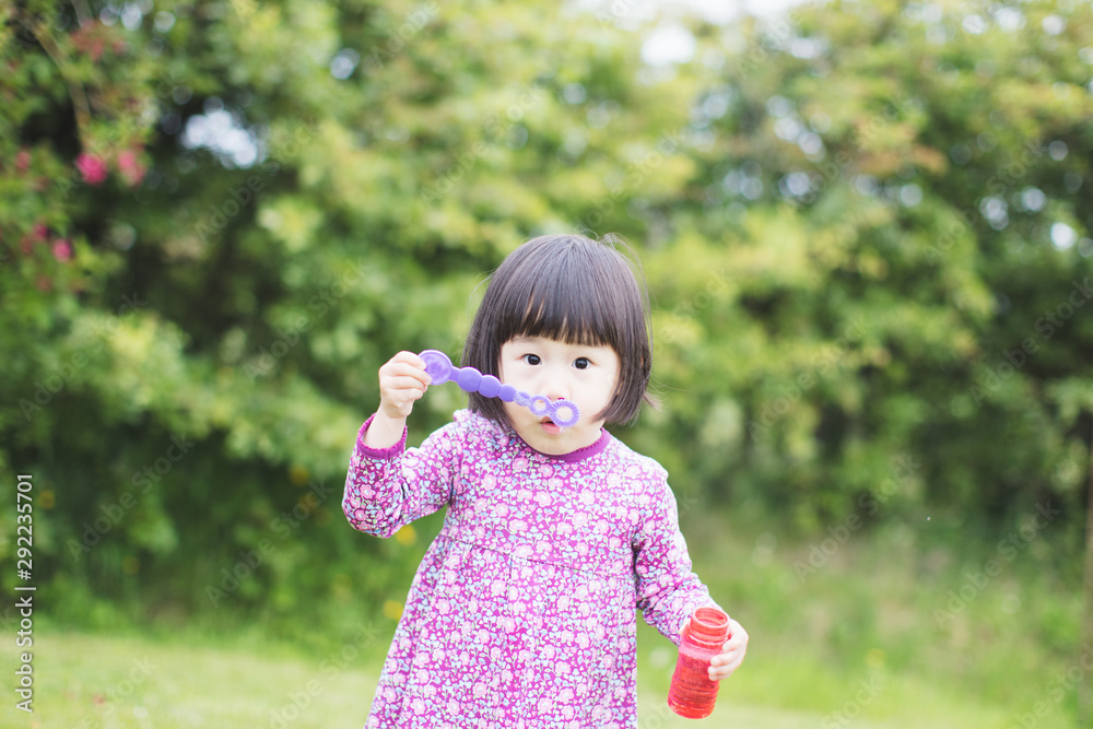toddler girl blowing soap bubbles at summer home garden toddler girl blowing soap bubbles at summer home garden