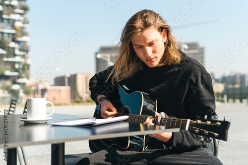 man playing the guitar and studing music composition photo