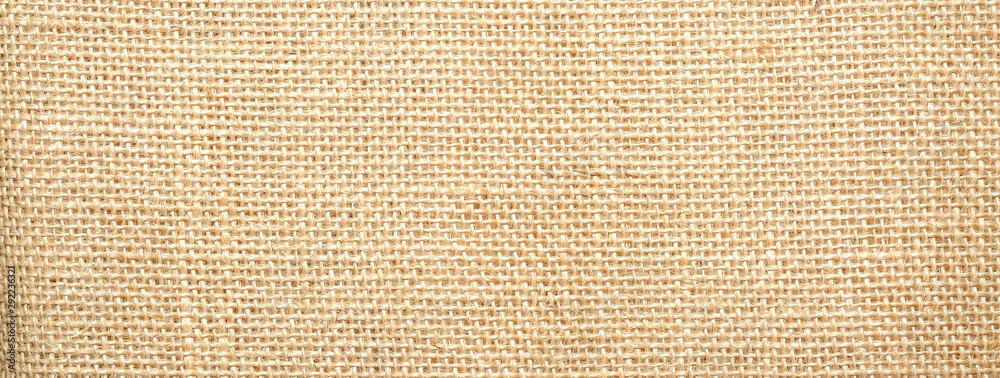 Fototapeta premium Cotton woven fabric background with flecks of varying colors of beige and brown. with copy space. office desk concept / Hessian sackcloth burlap woven texture background