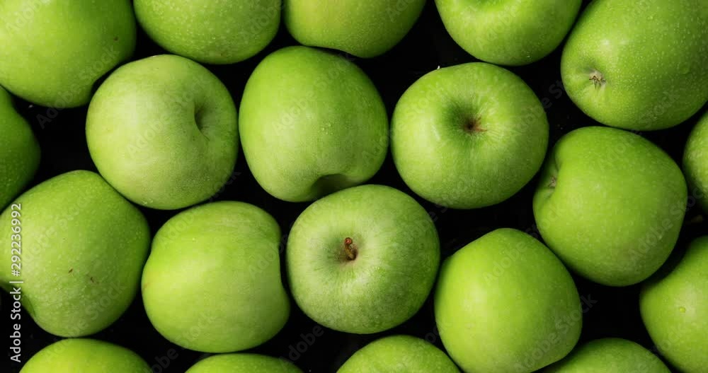 Green apples on black background, slow zoom in Green apples on black background, slow zoom in