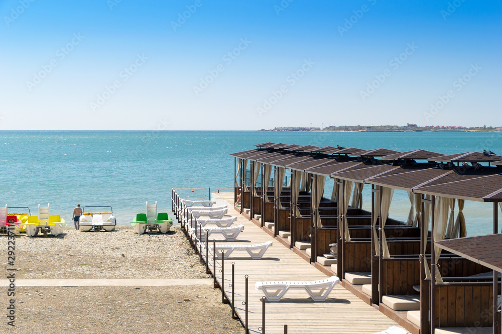 Beach wooden bungalows on the sea. Scenic view brown beach vip pavilions on Black Sea shore. Gelendzhik resort, Russia.