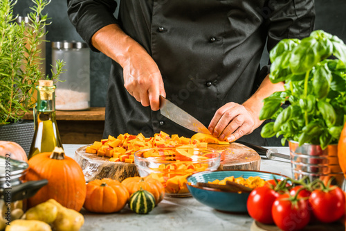 Chef cutting fresh and delicious pumkin and vegetables for cooking soup