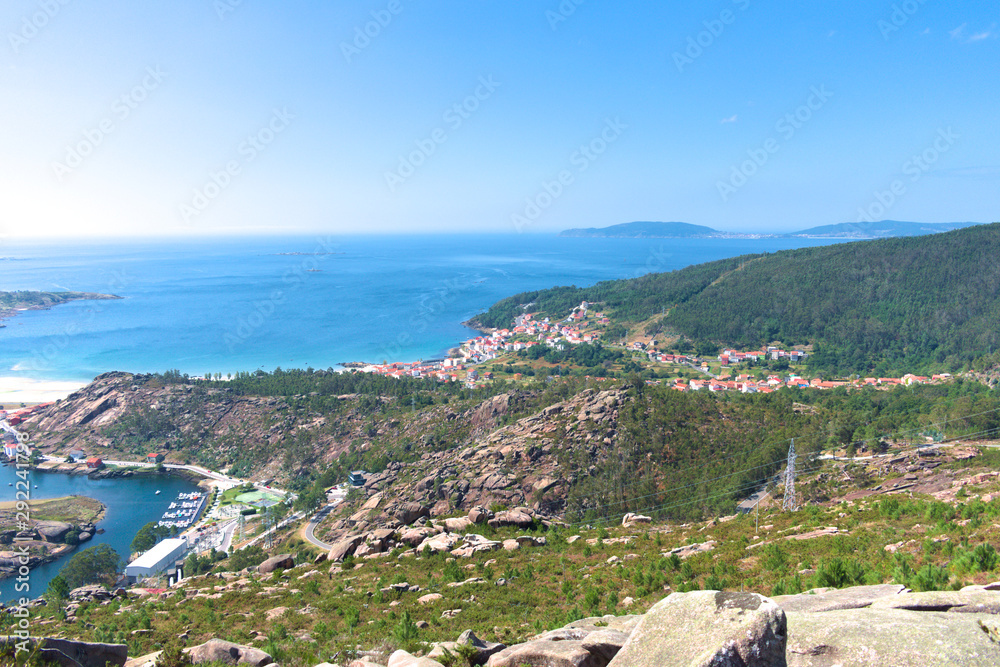 View of a coastal village in Galicia. Port at the left, the village on the middle, forest and the atlantic ocean.