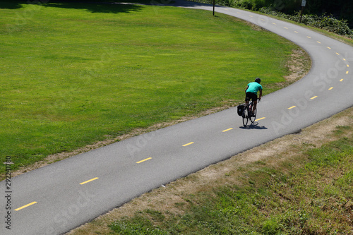 Cyclist riding on a bicycle path. Park on the Sammamish River in Redmont.