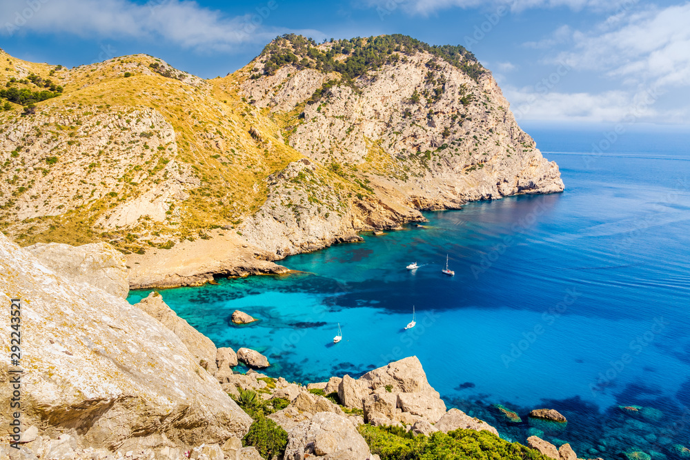 Beautiful coastline view of the cliffs with clear turquoise water and yachts. Cala Figuera beach on Cap de Formentor, Mallorca, Spain