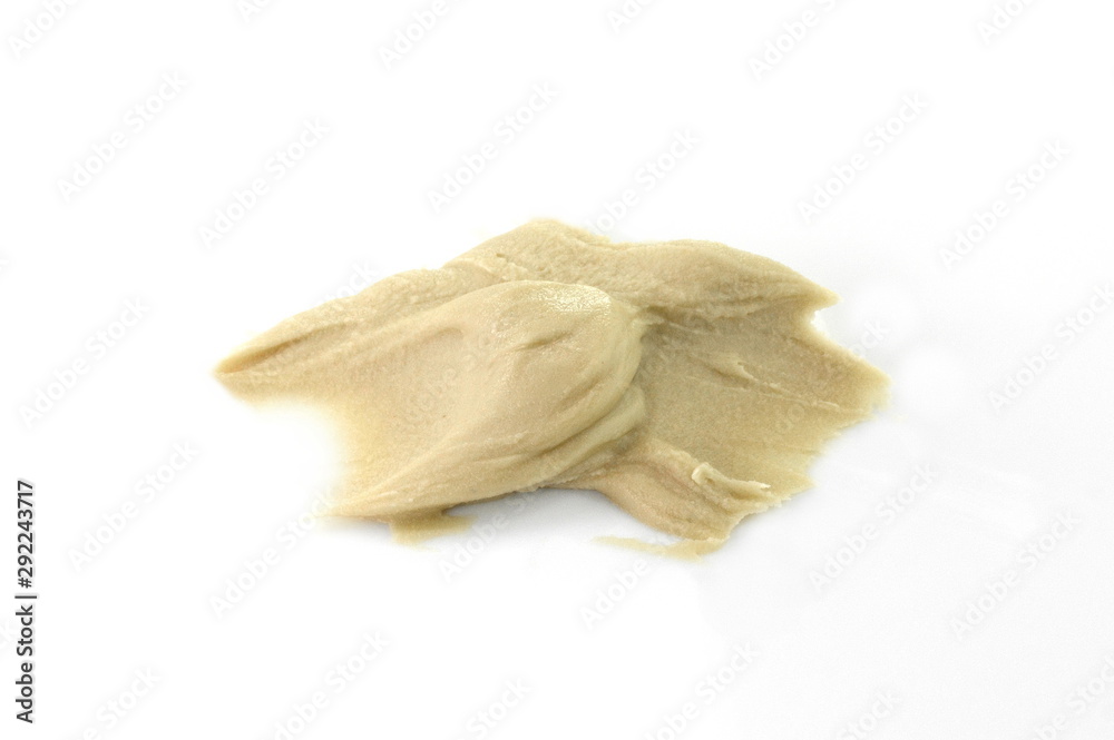 Tahini sauce (sesame seed paste) isolated on white background. Tahini paste smeared on a white surface. Tahini sauce (sesame seed paste) isolated on white background. Tahini paste smeared on a white surface.