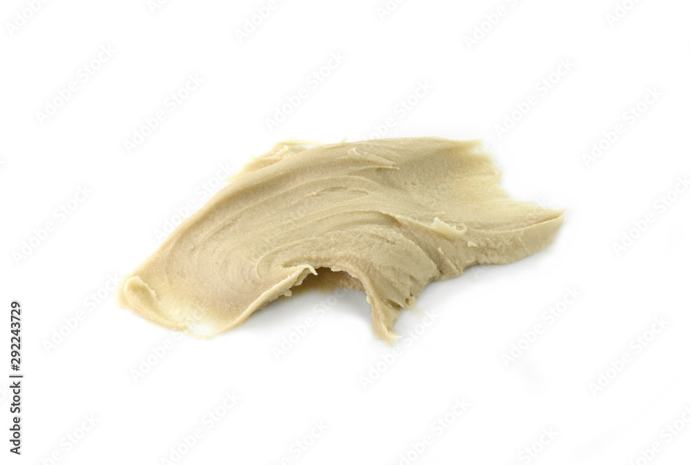 Tahini sauce (sesame seed paste) isolated on white background. Tahini paste smeared on a white surface. Tahini sauce (sesame seed paste) isolated on white background. Tahini paste smeared on a white surface.