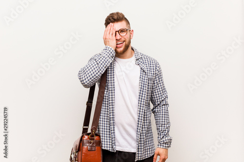 Young modern business man having fun covering half of face with palm. © Asier