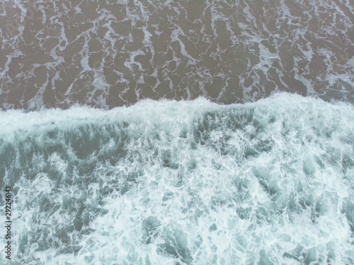 Abstract texture of water with waves and sand. Top view of turquoise water as background, Ocean, sea, lake.