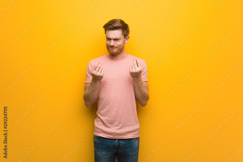 Young redhead man doing a gesture of need Young redhead man doing a gesture of need