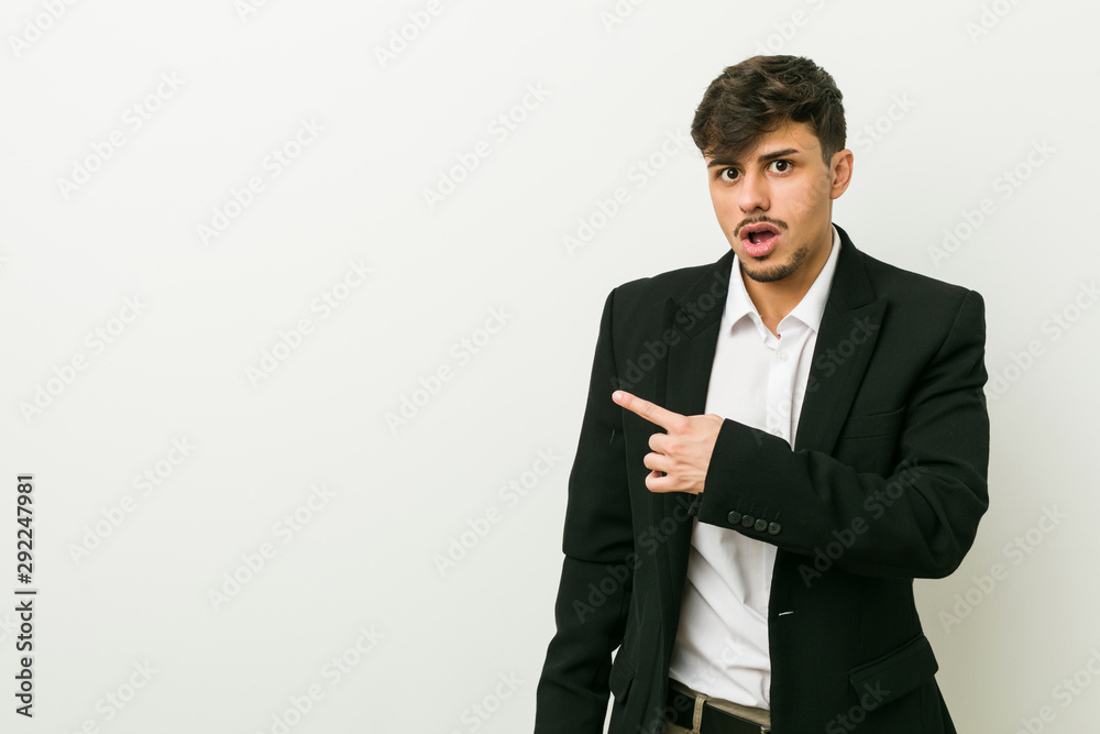 Young business hispanic man pointing to the side Young business hispanic man pointing to the side