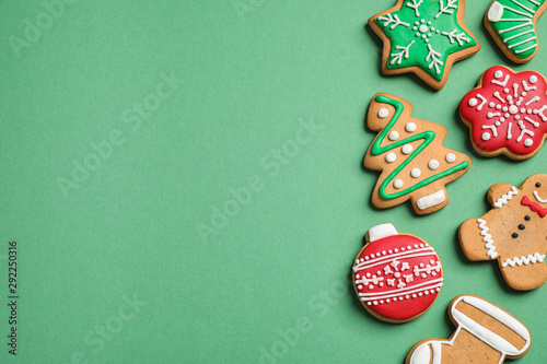 Flat lay composition with tasty homemade Christmas cookies on green background, space for text