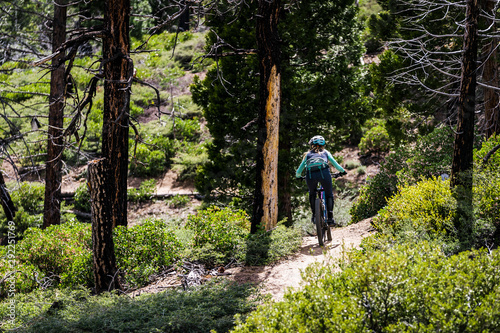female mountain biker riding through the woods