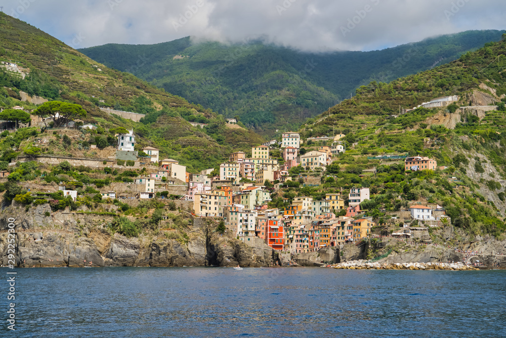 Riomaggiore, Cinque Terre, Italy - August 17, 2019: Village by the sea bay, colorful houses on the rocky coast. The protected area of â€‹â€‹the mountains. A popular resort in Europe