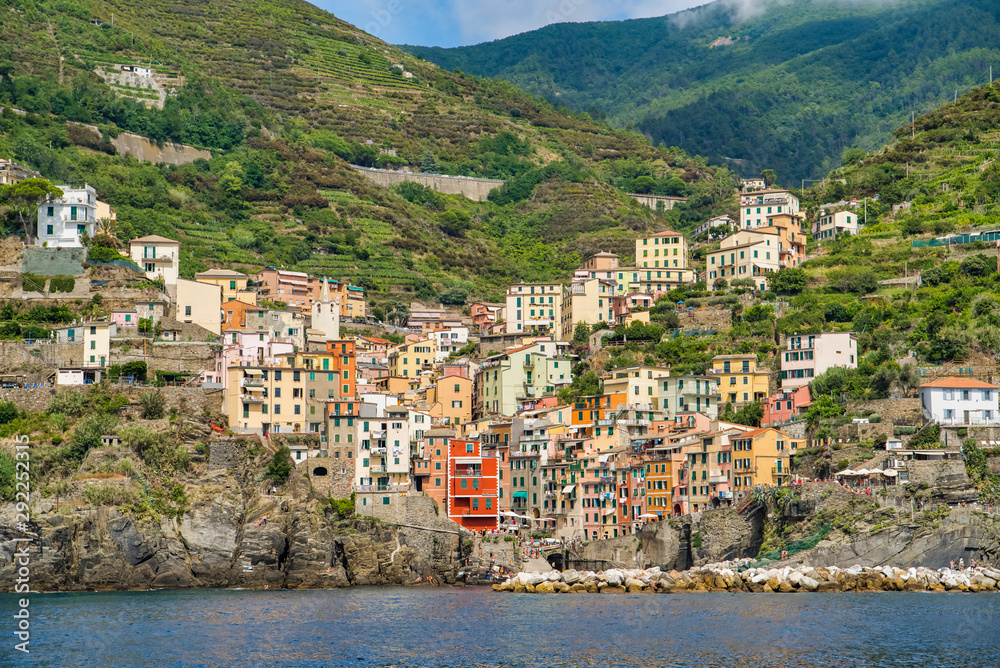 Riomaggiore, Cinque Terre, Italy - August 17, 2019: Village by the sea bay, colorful houses on the rocky coast. Nature reserve resort popular in Europe