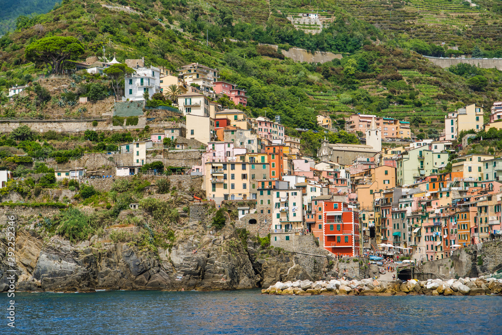 Riomaggiore, Cinque Terre, Italy - August 17, 2019: Village by the sea bay, colorful houses on the rocky coast. The protected area of â€‹â€‹the mountains. A popular resort in Europe
