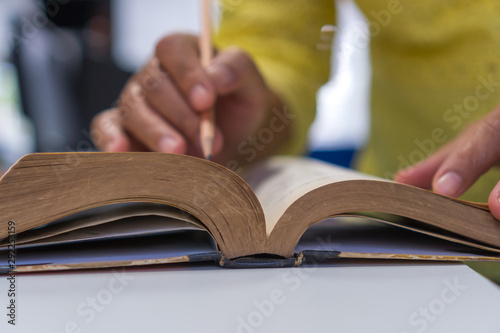 People reading old book for education learning concept : Young man opening textbook for read relax or study searching information in books for knowledge.