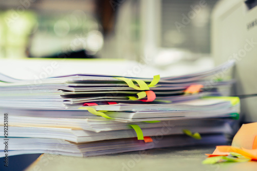 Stack of overwork of document report with post-it in business busy concept: Piles of paper files with postit on paperwork in overload at modern office
