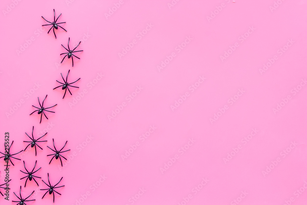 Minimalistic Halloween frame with small spiders on pink background top view space for text