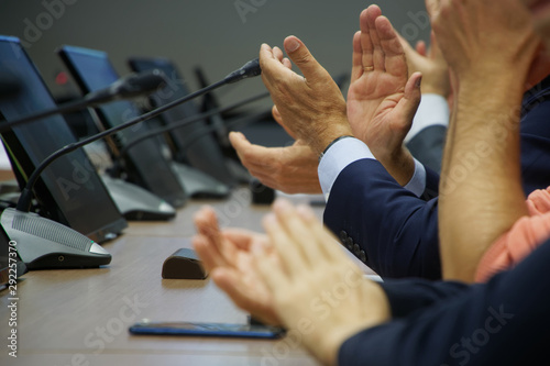 Applause. Participants in a meeting or discussion express their support and agreement for the speaker. Managers or officials. Shallow depth of field