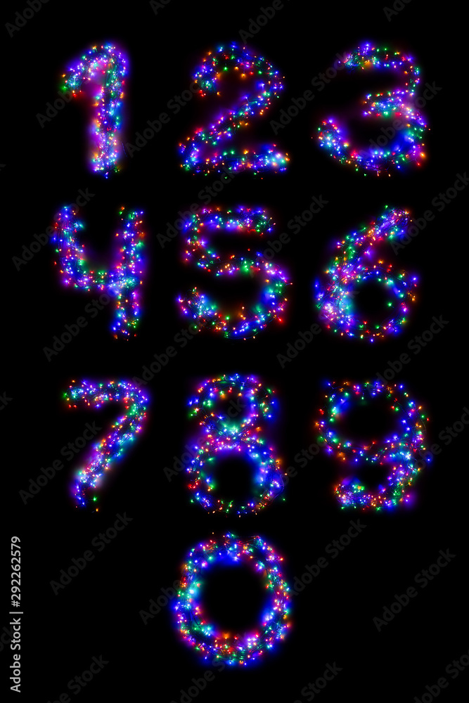 Arabic numerals from a multi-colored electric garland on a black isolated background. New year numbers. A wreath of colored light bulbs. Congratulations frame concept