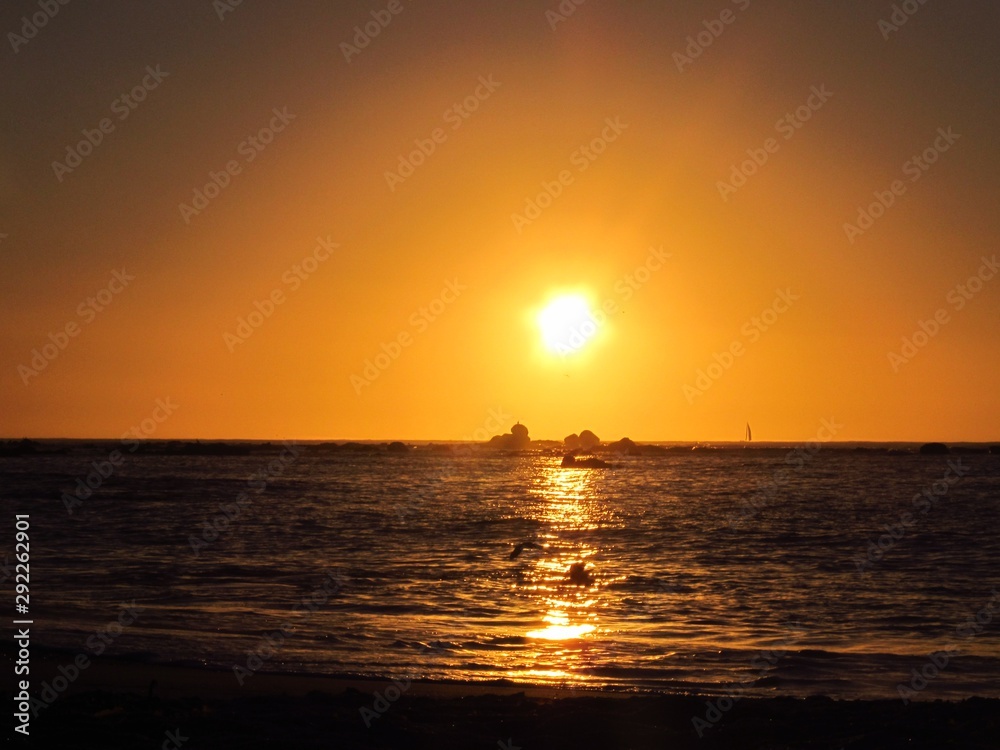 A beautiful sunset with the sun approaching the horizon at the sea seen from the beach of Algarrobo, Chili