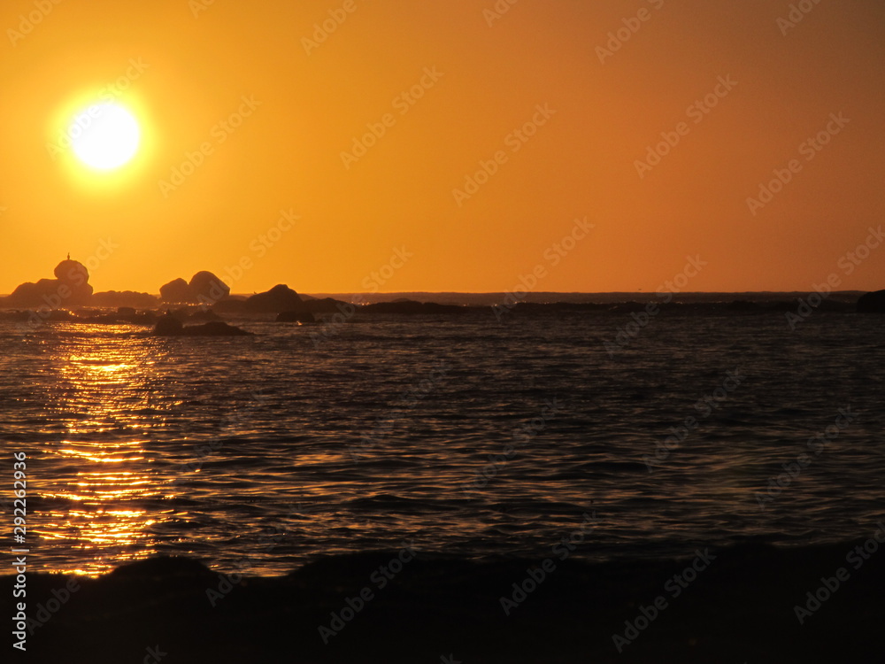 A beautiful sunset with the sun approaching the horizon at the sea seen from the beach of Algarrobo, Chili