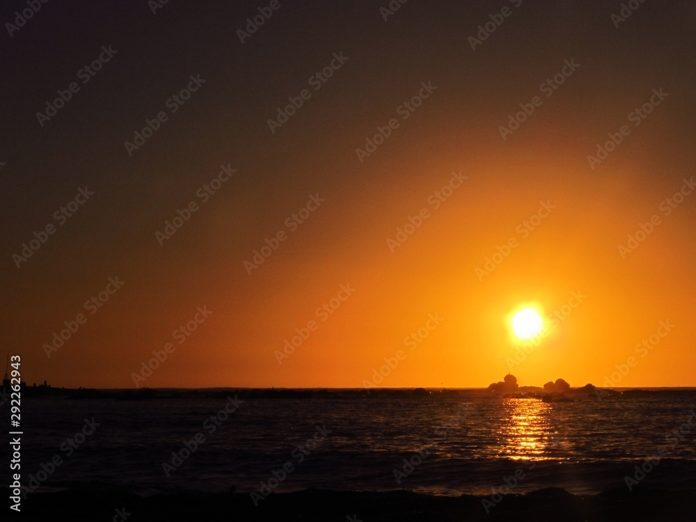 A beautiful sunset with the sun approaching the horizon at the sea seen from the beach of Algarrobo, Chili