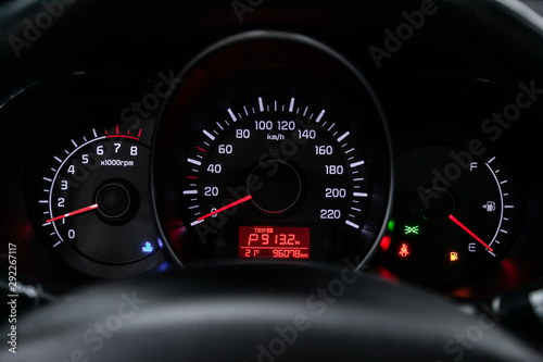 Car dashboard with white backlight: Odometer, speedometer, tachometer, fuel level, water temperature and more.