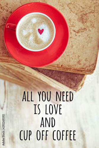 All you need is love and cup off coffee. coffee in red Cup and books. beautiful composition with Cup of cappuccino on rustic background. romantic concept. top view. 