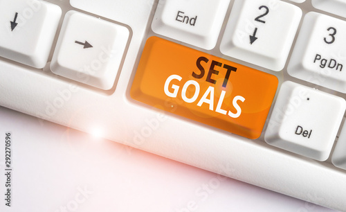 Writing note showing Set Goals. Business concept for Defining or achieving something in the future based on plan White pc keyboard with note paper above the white background photo